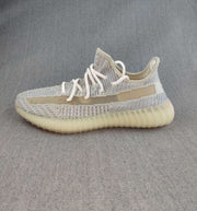 Single side profile of the gray and cream Yeezy 350 V2 sneaker.