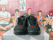 Front view of black and red high-top basketball sneakers displayed on a box.