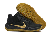 Black Nike sneaker displayed with its gum-colored outsole facing upward, showing the wavy tread pattern.