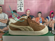Side profile of a brown PUMA sneaker showing cream side detailing and a textured sole