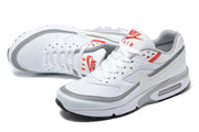 Pair of white and grey Nike Air Max sneakers with red tongue details