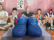 Pair of blue Nike sneakers viewed from the front, showing the laces and textured toe area.