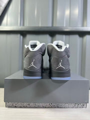 Rear view of grey high-top sneakers showing white heel logos, black midsoles, translucent blue outsoles, and a grey shoe box.