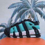 Close-up side view of a black and bright green Nike high-top sneaker with white and translucent sole details.