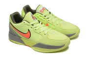 Angled view of the yellow-green sneakers showing mesh toe panels, laces, orange side details, and gray midsoles.