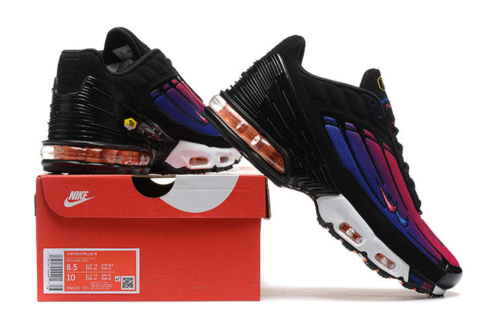 Black Nike Air Max Plus sneakers with pink and purple gradient panels displayed with a red shoe box; the box label shows US sizes 8.5 and 10.