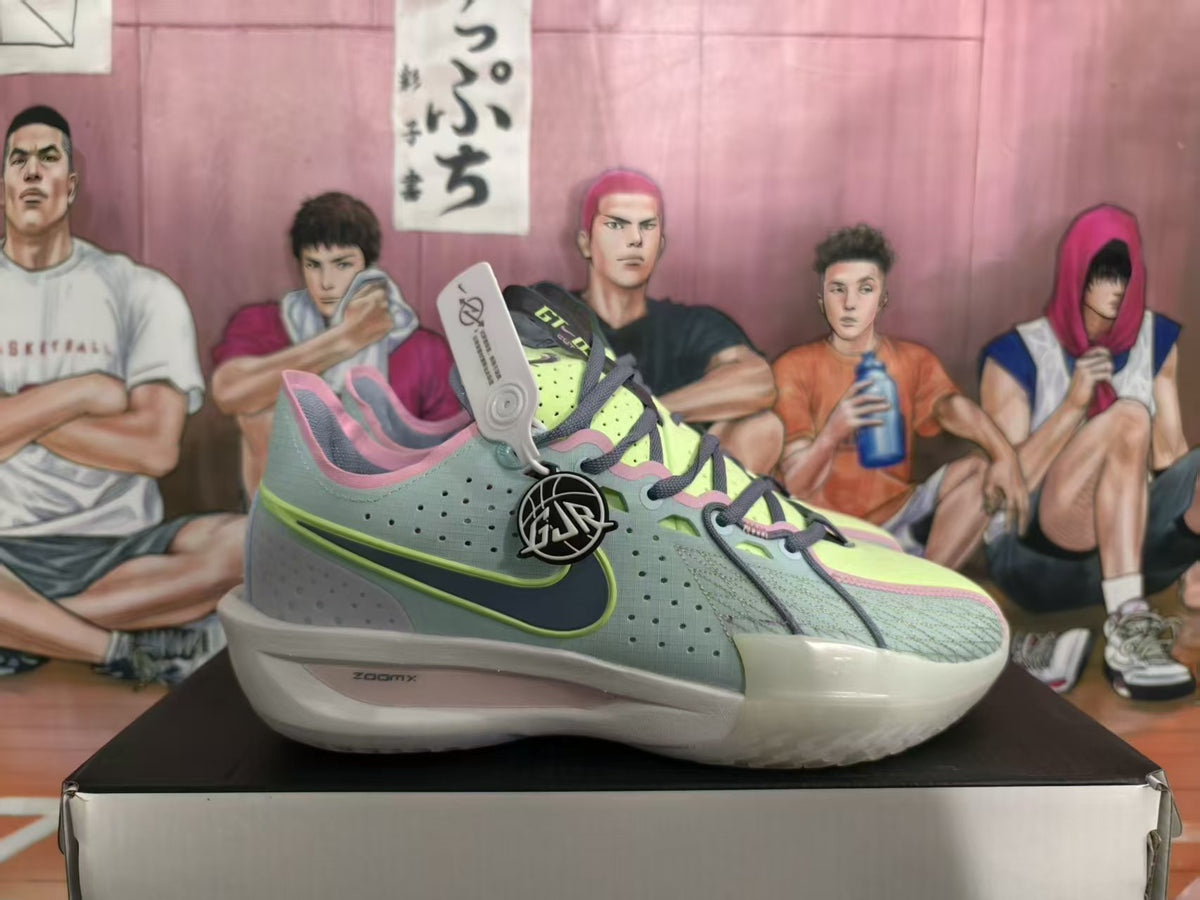 Pair of blue-green Nike basketball sneakers with lime accents, pink trim, dark laces, and a visible Sabrina-style circular side emblem on a shoe box.