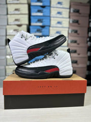Two Jordan Air Jordan 12 sneakers arranged together on a shoebox, showing their side profiles and contrasting colors.