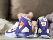 Rear view showing the padded heels, purple overlays, white heel panels, and orange details.