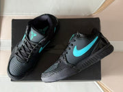 Top-down front view showing the perforated toe panels, black laces, turquoise tongue emblems, and side branding.
