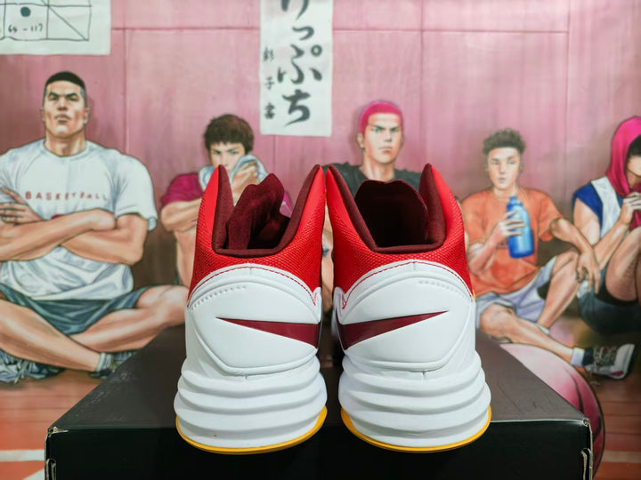 Rear view of red and white high-top basketball shoes with white heel panels, red accents, layered midsoles, and yellow outsole edges.