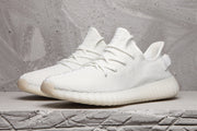 White Yeezy 350 V2 sneakers shown together from a front three-quarter angle.