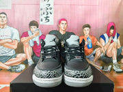 Front view of black sneakers with elephant-print toe overlays, black laces, and light-colored tongues.