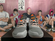 Front view of grey Nike KD sneakers showing patterned uppers, orange-accented laces and light-grey toe overlays.
