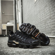 Black and gold Nike TN-11 sneakers with outsole visible