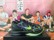 Side view of black Nike Kobe basketball shoes with textured uppers and bright accent details.