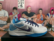 Side profile of a blue and white Nike sneaker showing the large dark purple Swoosh, textured blue side panels and blue outsole.