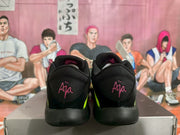 Rear view of black Nike basketball sneakers with pink Ja heel markings and green side accents on a shoebox.