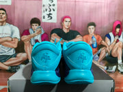 Rear view of blue Nike sneakers showing padded heels and embroidered heel details on a box.