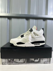 Side profile of a white Air Jordan 4 sneaker with black midsole accents and red tongue detailing.