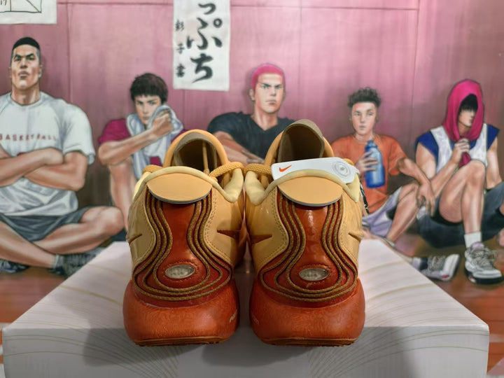 Rear view of peach-pink Nike basketball sneakers with brown-orange heel accents and a basketball mural in the background.
