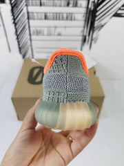 Rear view showing the gray heel construction, orange collar trim, and translucent sole.