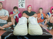 Front view of white lace-up Nike basketball shoes with textured uppers and sculpted toe areas.