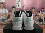 Rear view showing green Nike-style branding and AIR lettering on the white sneaker heels.