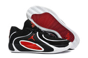 Angled view showing the black and white sneaker uppers, red side accents, and patterned red-and-white outsole.