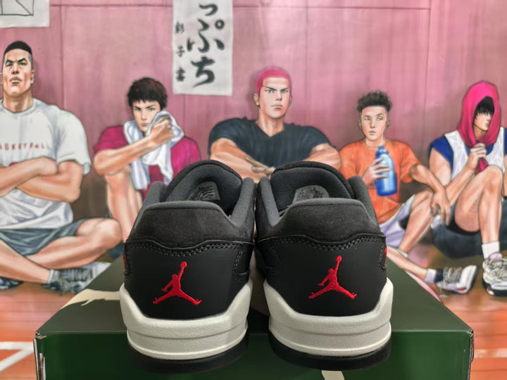 Rear view of black and grey Jordan sneakers with red heel logos and light-colored midsoles.