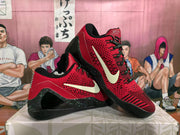 Angled view of the red and black Nike sneakers displaying the side Swoosh, patterned laces, and speckled heel detailing.