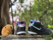 Rear and side views of the black shoe with blue and purple accents.