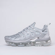 Side profile of a silver-gray Nike TN-4 sneaker with a clear segmented sole