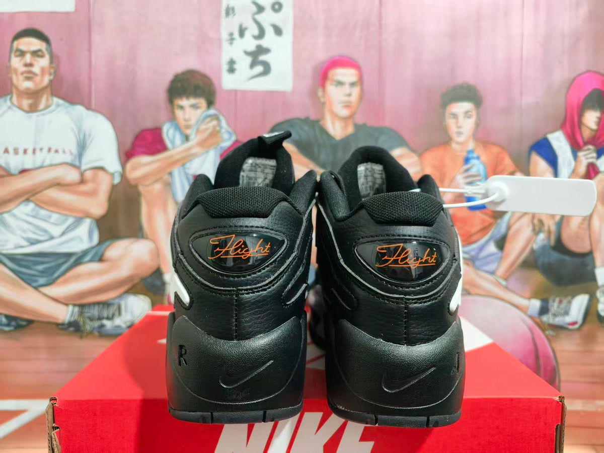 Rear view of black Nike sneakers showing orange Flight branding and a black Nike shoebox.
