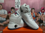 Angled view of white high-top basketball shoes with speckled overlays, black Swoosh details, and blue-toned outsole accents; a circular heel detail shows 35.
