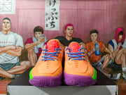Front view of orange basketball shoes with blue laces and purple toe accents