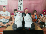Front view of the pair showing white laces, white uppers, black toe overlays, and red accents.