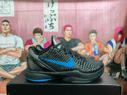 Side view of a black Nike basketball sneaker with blue Swoosh detailing and a black-and-blue sole on a shoebox.