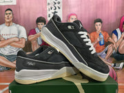 Angled view of black and gray low-top sneakers with white laces, visible Jumpman branding, and textured outsoles.