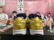 Rear view of gold and navy basketball shoes with a white midsole and number 10 heel details
