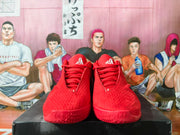 Front view of red lace-up basketball shoes with logo details on the tongues.