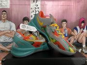 Angled view of multicolor Nike basketball sneakers with yellow laces, gray side panels, teal heel sections, and visible Nike swooshes.