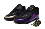Pair of black, purple and gold Nike LeBron 23 basketball shoes shown from the front.
