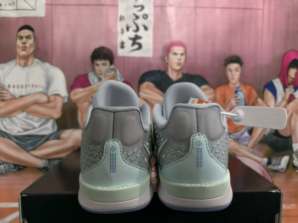 Rear view of sky blue and grey Nike basketball sneakers showing padded heel collars, stitched rear panels, and contrasting outsoles.