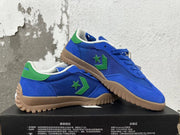 Pair of blue Converse shoes with green accents and textured gum-colored outsoles
