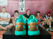 Rear view of turquoise basketball sneakers with metallic gold heel panels and turquoise signature-style heel graphics.