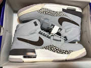 Pair of grey and white high-top sneakers placed inside a shoebox, viewed from above.