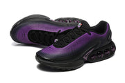 Pair of black and purple Nike Air Max DN sneakers shown from a three-quarter angle
