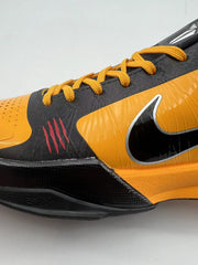 Close-up of the orange and black side panels, yellow-orange laces, and Swoosh.