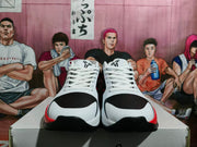 Front view of matching basketball sneakers showing white laces, black perforated toe panels, red trim, and basketball logos on the tongues.